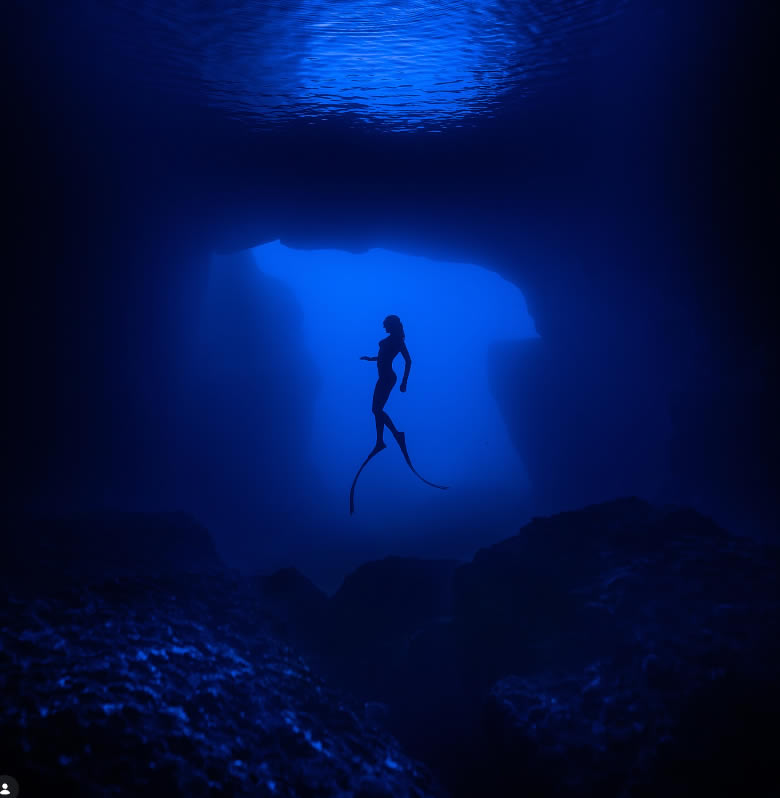 Freediver silhouetted against the entrance to Cathedral Cave, Gozo