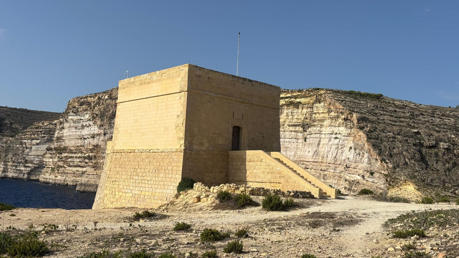 Xlendi Tower and the coastline at Xlendi Bay